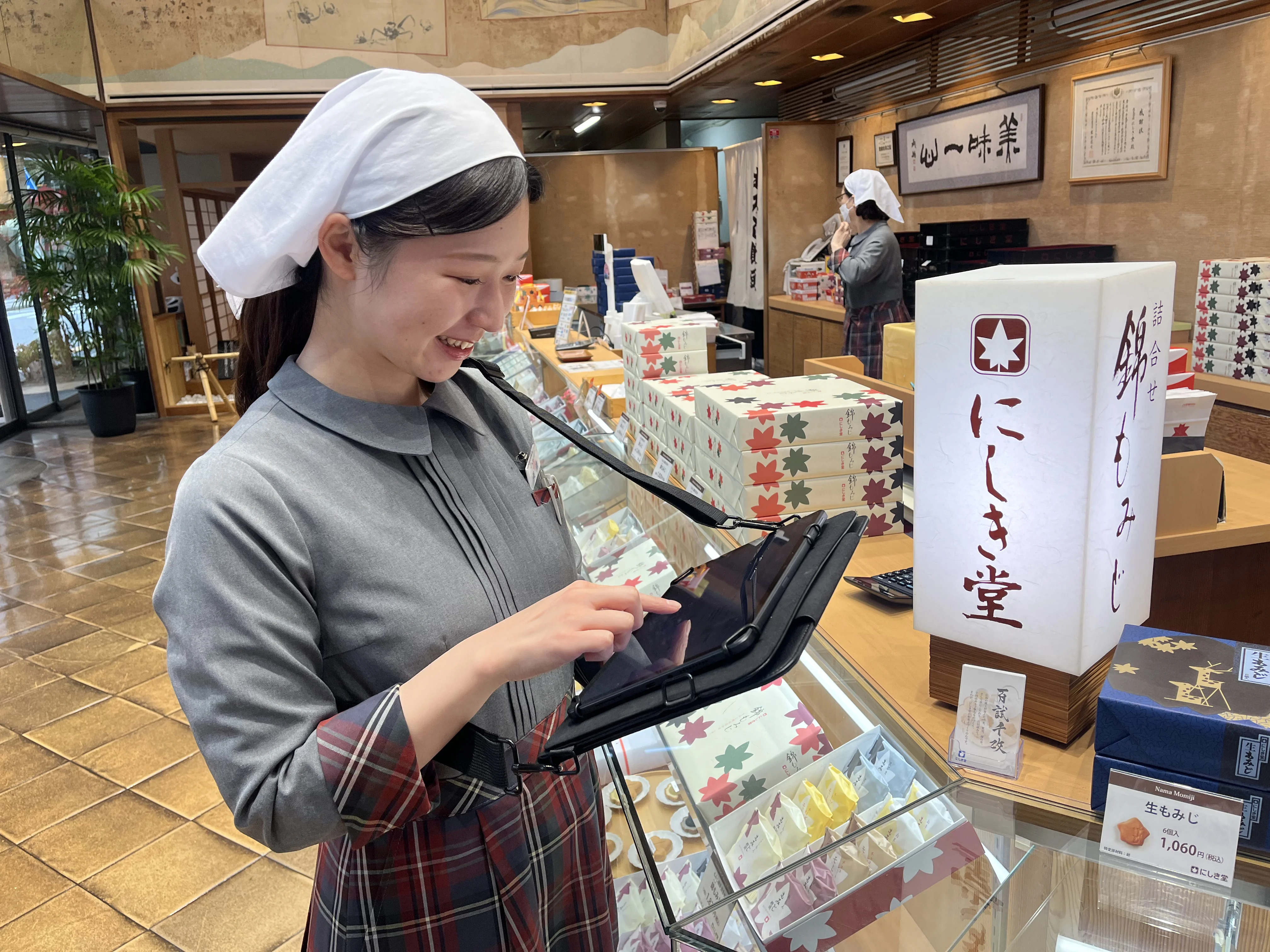 株式会社にしき堂様 - 店舗でタブレットを使用する様子